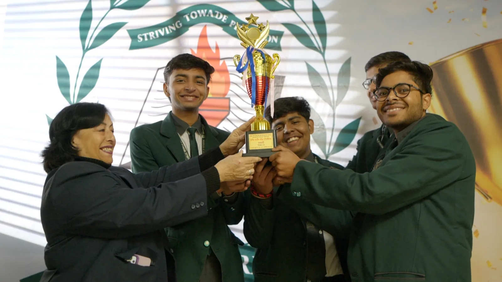 Students lifting a trophy with their teacher